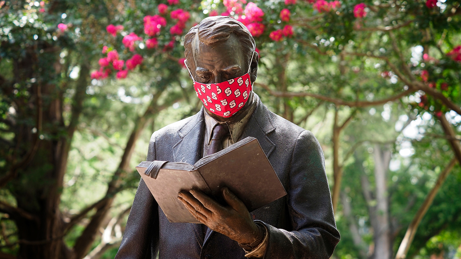 strolling professor statue wearing mask