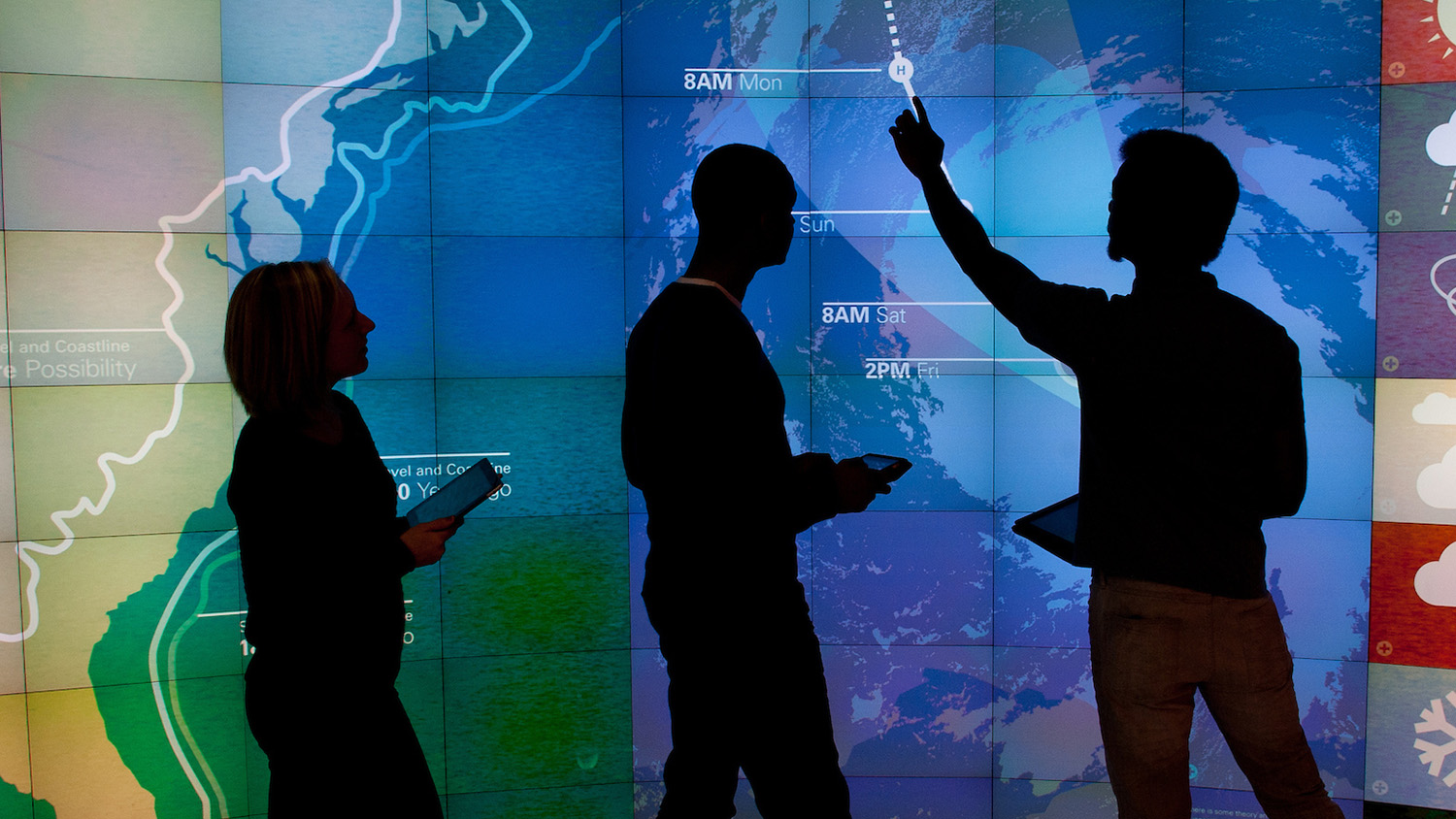students standing in front of map in visualization lab
