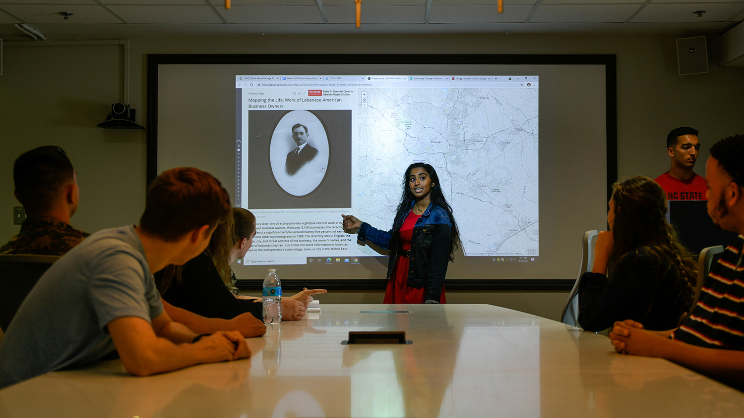 A student gives a presentation inside a dark room