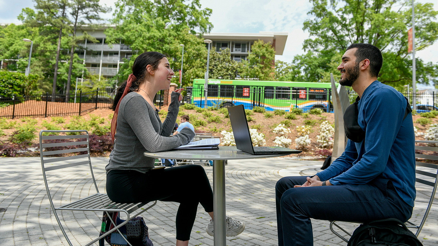 Students sit at a table and chat on NC State's campus